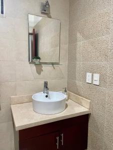 a bathroom with a white sink and a mirror at Charming Condo in Gaviotas Walk to Beach cafes, restaurants within Golden Zone in Mazatlán +44 photos