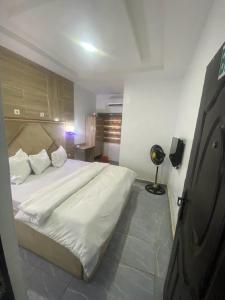 1 dormitorio con 1 cama blanca grande en una habitación en De Emeritus Courtyard en Kubwa