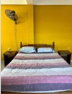 a bedroom with a large bed with a fan at Urbano in Tarija
