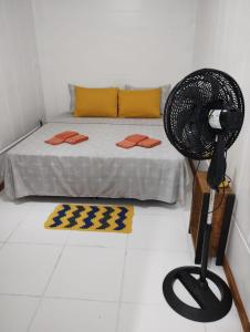 Zimmer mit einem Bett und einem Ventilator auf dem Boden in der Unterkunft Celebre Cama e Café (B&B) in Florianópolis