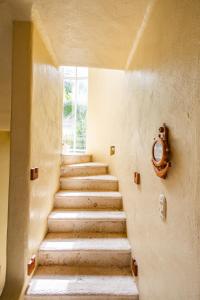 a set of stairs with a clock on the wall at Villas Xaguar by PlayaSky in Playa del Carmen