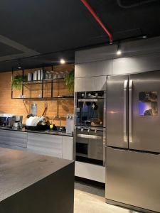 una cucina con frigorifero e piano cottura in acciaio inossidabile di RioDowntown - Rede Nosso Cantinho a Rio de Janeiro