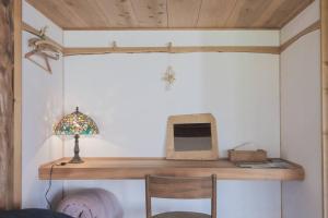 a room with a wooden shelf with a monitor and a lamp at "八ヶ岳山麓の小さな家" in Hara