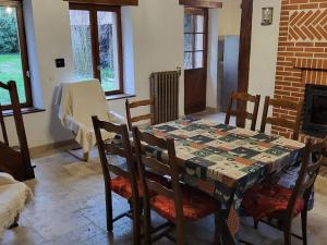 a dining room with a table with chairs and a fireplace at Gîte typique avec étang privé, linge et ménage inclus, Wi-Fi et animaux gratuits - FR-1-591-378 in Rosnay
