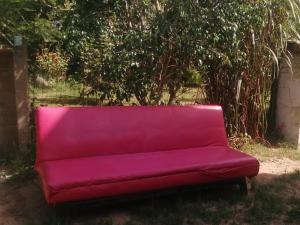 a red couch sitting in the grass in a yard at Per a Tu in Punta del Este