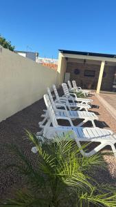 里韋拉的住宿－Casa con piscina y barbacoa，坐在大楼顶上的一排白色草坪椅