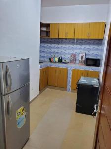 uma cozinha com um frigorífico de aço inoxidável e um balcão em Allada-appart em Allada
