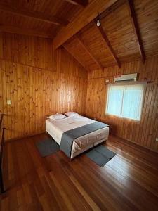 um quarto com uma cama num quarto de madeira em Urú em Puerto Iguazú