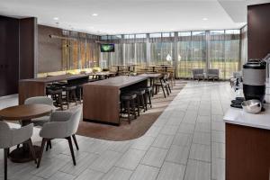 SpringHill Suites by Marriott Roanoke في رونوك: غرفة طعام مع طاولات وكراسي ونوافذ