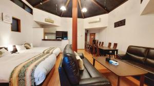 1 dormitorio con cama, sofá y mesa en DAVID NO YAKATA - Vacation STAY 16849v, en Yufu