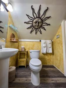 a bathroom with a toilet and a sun on the wall at Vinoy House in St Petersburg