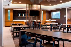 a restaurant with tables and chairs and a flat screen tv at SpringHill Suites by Marriott Tampa Suncoast Parkway in Land O' Lakes