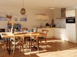 a kitchen and dining room with a wooden table and chairs at Sunny apartment directly on the Heegermeer in Heeg