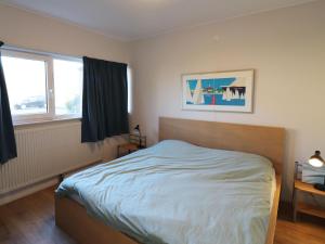 a bedroom with a bed and two windows at Apartment in Heeg with Heegermeer Views in Heeg