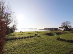 a grassy field with benches and a body of water at Sunny apartment directly on the Heegermeer in Heeg