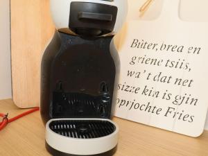 a coffee maker sitting on a table next to a sign at Sunny apartment directly on the Heegermeer in Heeg