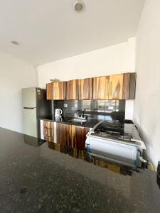 una cocina con armarios de madera y un aparato de acero inoxidable en Hotel TNT Mirador, en Taganga