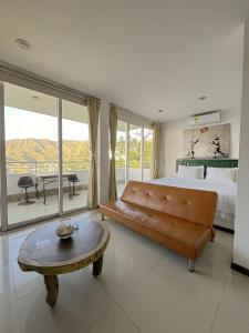 a bedroom with a couch and a table and a bed at Hotel TNT Mirador in Taganga