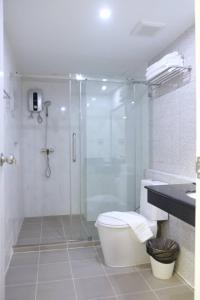 a bathroom with a shower and a toilet and a sink at Christella Hotel Laemchabang in Si Racha