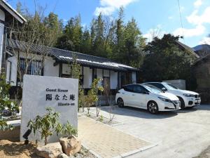 Deux voitures blanches garées devant une maison dans l'établissement Hinata-an Botan - Vacation STAY 86855, à Yufu