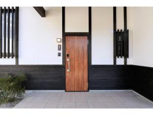 une porte en bois sur le côté du bâtiment dans l'établissement Hinata-an Botan - Vacation STAY 86855, à Yufu