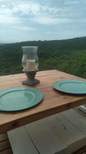 een vaas op een houten tafel met twee platen bij Modulo - Gorska Voda in Embalse