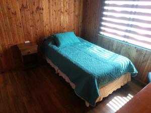 チョンチにあるCasa Chonchi, Chiloéのベッドルーム1室(青い掛け布団、窓付)