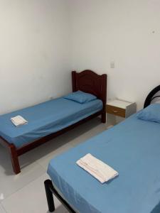 - 2 lits dans une chambre avec des draps bleus dans l'établissement Casa do sol - Marechal, à Marechal Deodoro