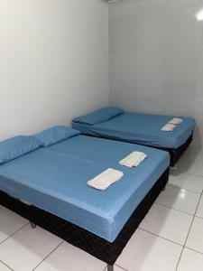 - 2 lits dans une chambre avec des draps bleus dans l'établissement Casa do sol - Marechal, à Marechal Deodoro