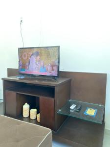 - une télévision assise au-dessus d'une table dans l'établissement Casa do sol - Marechal, à Marechal Deodoro