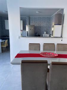 une salle à manger avec une table et des chaises ainsi qu'une cuisine dans l'établissement Casa do sol - Marechal, à Marechal Deodoro