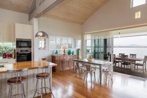 a kitchen and dining room with a table and chairs at 'South Pacific' - Luxury Oceanfront at Culburra! in Culburra Beach