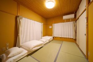 een kamer met 3 bedden en een raam bij YUFUIN KYOAN - Vacation STAY 87589 in Yufu