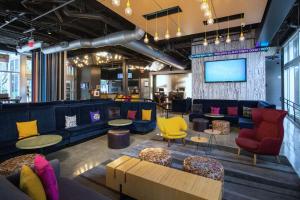a lobby with couches and chairs and a tv at Aloft Miami Doral in Miami