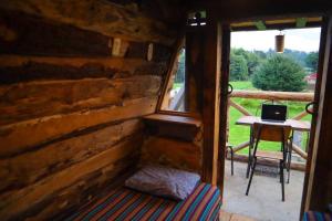 a log cabin with a window and a laptop on a table at Fuego - Wood Cabin Tecpan (No Wifi, Relax) in Tecpán Guatemala