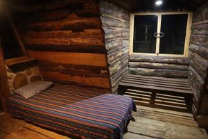 a room with a bed and a window in a log cabin at Fuego - Wood Cabin Tecpan (No Wifi, Relax) in Tecpán Guatemala