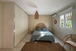 a bedroom with a bed and a window at Anse des Caraïbes in Les Trois-Îlets