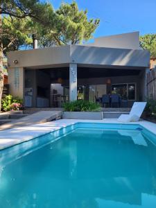 a swimming pool in front of a house at Casa Boutique LUNA LUCIA in Monte Hermoso