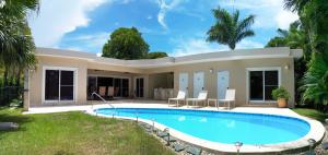 une villa avec une piscine en face d'une maison dans l'établissement Chic Villa with King Room BBQ Pool Restaurant Shuttle, 
