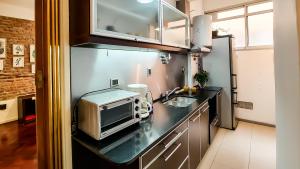 una cocina con fregadero y microondas en una encimera en Amplio y Hermoso con Hidromasaje en Buenos Aires