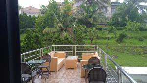 a balcony with chairs and tables and a view of a garden at Villa Puncak Tidar M-20 in Kasri