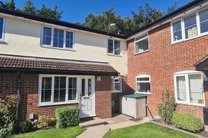 a brick house with white doors and a yard at Lovely house overlooking field with woodland walks in Blackwater