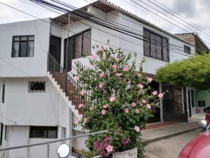 a white building with a staircase and pink flowers at Casa Descanso La Campiña 101 in Cali