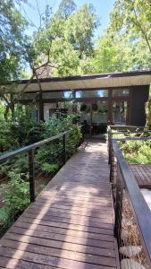 a wooden walkway leading to a building in a park at Departamento full equipado Pucón in Pucón