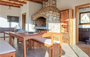 a kitchen with a wooden table and a stone fireplace at 3 Bedroom Nice Home In Brusane in Brušane