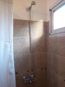 a shower with a shower head in a bathroom at Hermosa casa de campo y bosques in Toay