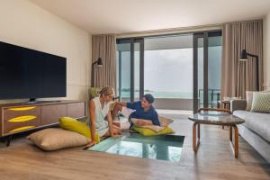 Le Méridien Maldives Resort & Spa في لْهلفياني أتول: رجل وامرأة يجلسون في غرفة المعيشة