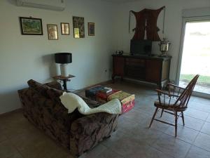 a living room with a couch and a chair at Hermosa casa de campo y bosques in Toay