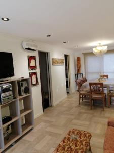 een woonkamer met een televisie en een eetkamer bij ROMFER in San Eduardo del Mar
