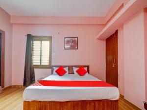 a bedroom with a large bed with red pillows at Hotel O Crown Square in Bhopal +41 photos